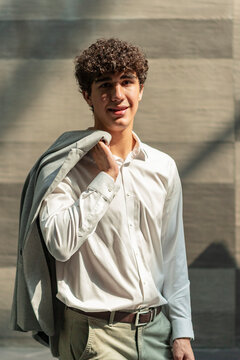 Young man portrait in sunlight holding jacket on shoulder