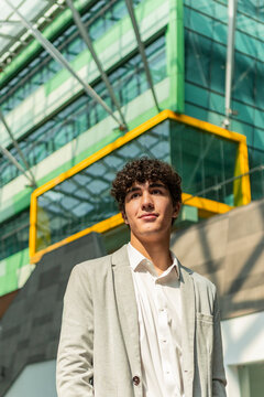 Young businessman in front of modern glass office building