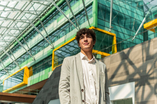 Young businessman in front of modern glass office building
