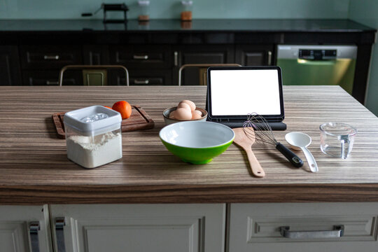 Baking setup with tablet recipe and ingredients on kitchen island