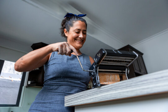 Woman making handmade pasta with a pasta machine at home
