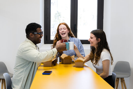 Coworkers celebrating with coffee during office lunch break
