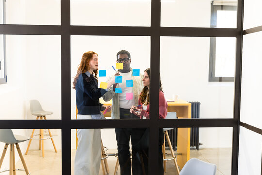 Team planning with sticky notes in modern office meeting