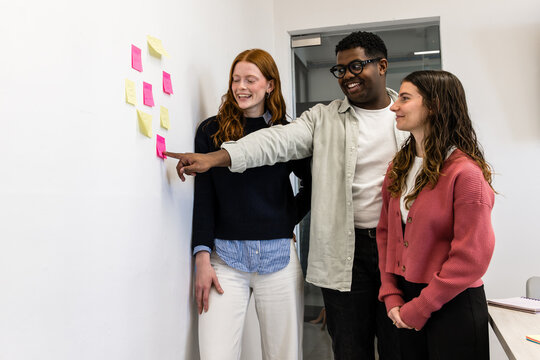 Diverse team reviewing sticky notes during agile meeting