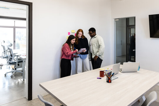 Diverse team reviewing notes together in modern office