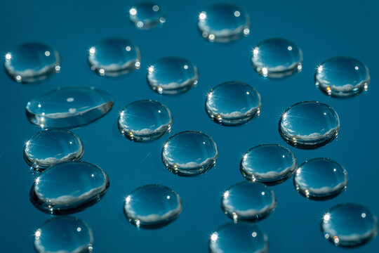Macro water drops on glass with blue reflective background