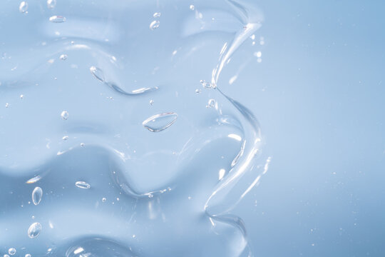 Transparent gel smear texture with bubbles on blue