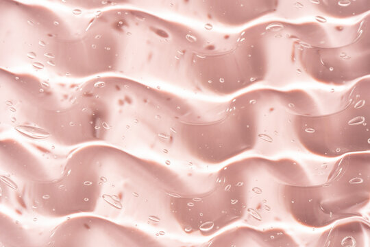 Abstract pink gel texture with glossy smear and bubbles