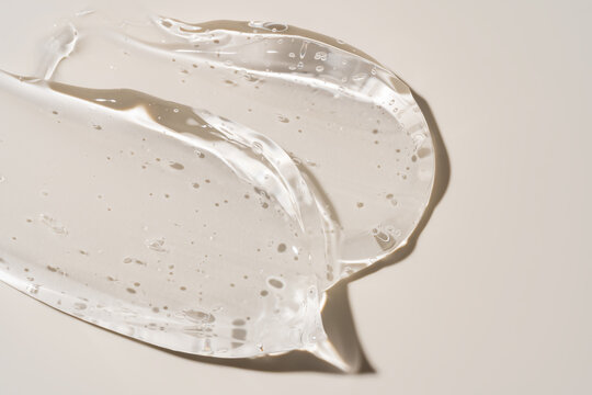 Clear gel smear texture with bubbles on neutral background