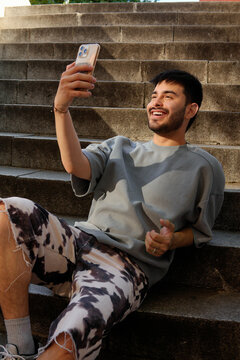 Fashionable urban man taking a selfie on city steps