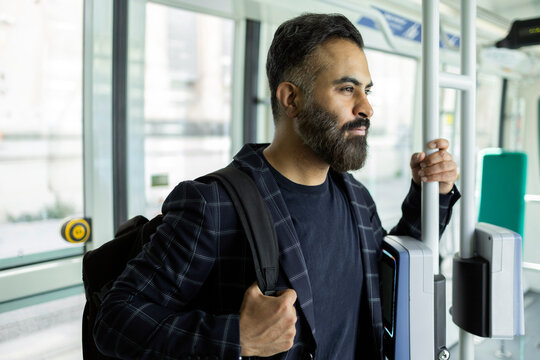Indian commuter standing in train near ticket validator