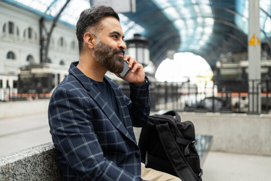 Indian businessman on phone at railway station concourse