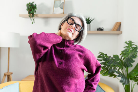 Senior woman stretching at home for daily wellness routine