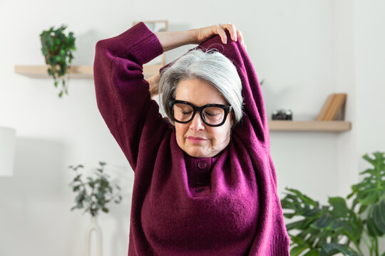 Senior woman stretching at home for daily wellness routine