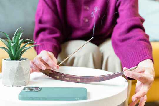 Senior woman practicing mindful incense ritual at home