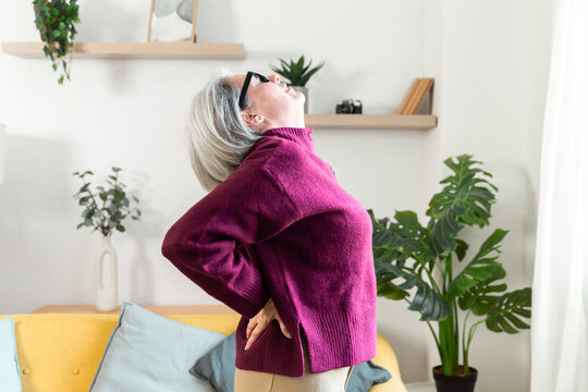 Senior woman stretching at home for daily wellness routine