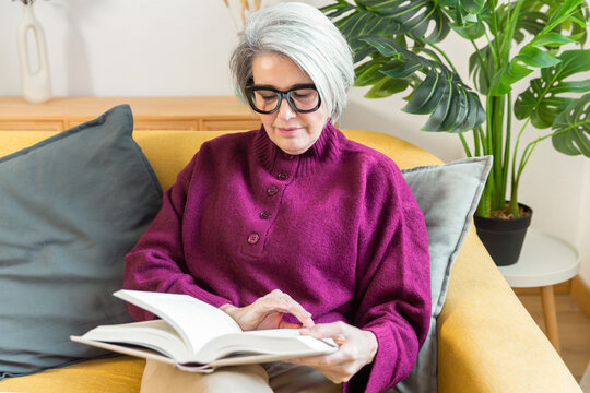 Senior woman reading at home as part of wellness routine