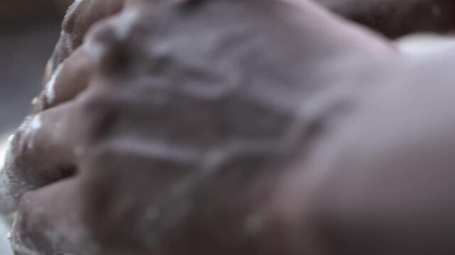 Close up shot of hands kneading fresh dough for traditional Indian flatbread preparation.