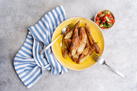 Mexican potato wedges with pico de gallo on a yellow plate