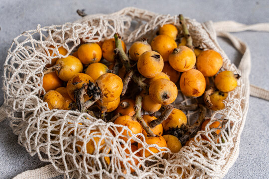 Ripe loquat fruit in net bag, healthy vitamin snack