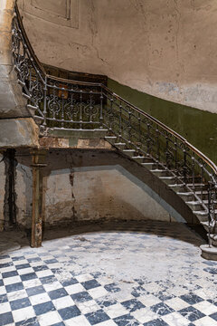 Abandoned architectural staircase with intricate railing