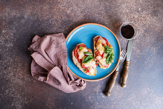 Toast with tomato basil and parmesano on blue plate