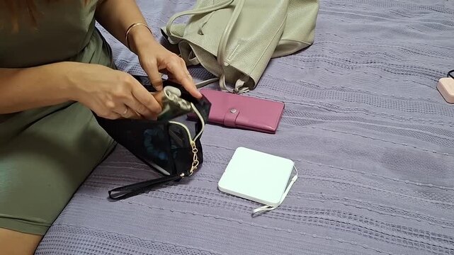 Sorting items inside a bag on the bed while preparing to go out