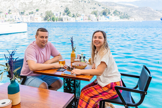 Couple dining at seaside cafe with turquoise bay view