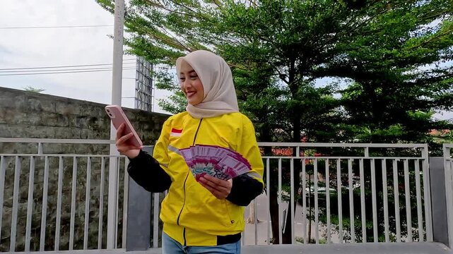 Asian muslim woman online motorcycle taxi drivers is holding money. Earning money from their work. Illustration for world women day.