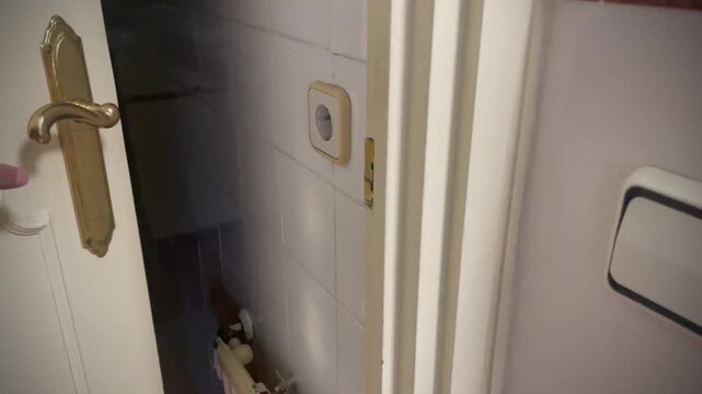 Entrar al ba&ntilde;o con pomo picaporte chirrido, abrir puerta de manilla, encender interruptor luz servicio y acceder a lavabo, sanitarios y papel higi&eacute;nico