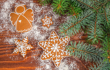 Fototapeta premium Christmas Gingerbread Cookies with Evergreen Branches on Rustic Wooden Background
