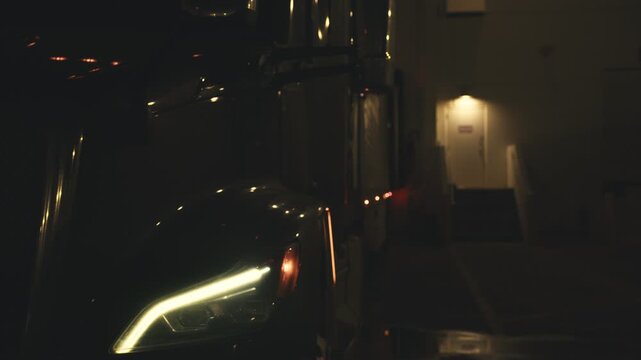 Commercial semi-truck idling at a loading dock at night