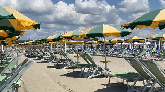 Beach with rows of colorful umbrellas and sunbeds on beach Versilia, Lucca, Tuscany Italy.