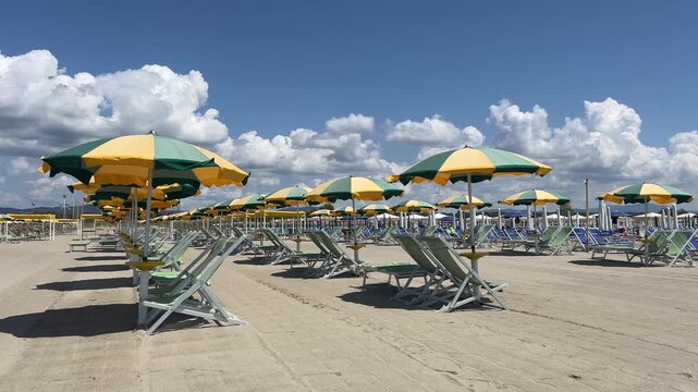 Beach with rows of colorful umbrellas and sunbeds on traditional beach in Versilia, Viareggio, Lucca, Tuscany Italy.
