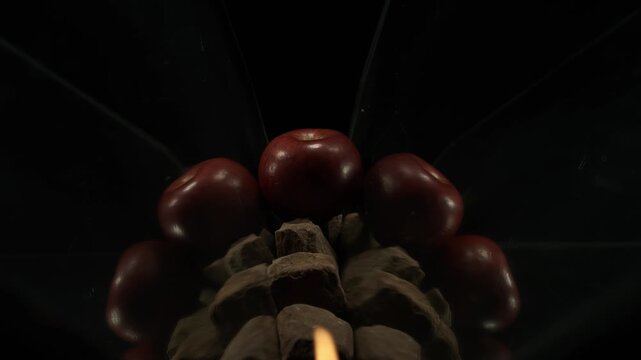 A double flash of particle spray and fire moves from the foreground to the back of a red apple in 1000fps slow motion. A dynamic display of ignition delay and moving combustion. Concept: dynamic spray