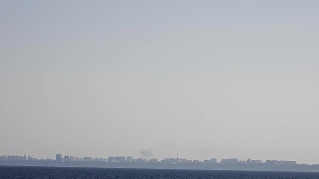 CHORNOMORSK, UKRAINE - JULY 18, 2026: A plume of smoke rises above the city skyline across the sea after a Russian Onyx (Oniks) missile strike on Chornomorsk in Odesa region.