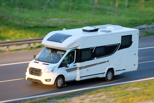 White Luxury Motorhome Camper Van Driving Along Highway, Freedom Travel Concept