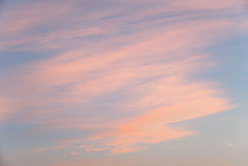 Fototapeta premium Soft sky background with pastel-colored clouds running at a slight angle, at sunset