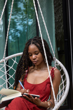 Woman Journaling in Hanging Chair, Mindfulness, write in notebook