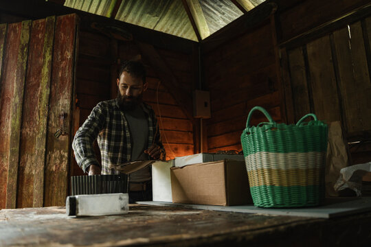 Adult working in rustic wooden shed with boxes