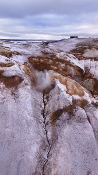 Vertical aerial view of geothermal steam rising from a volcanic ridge in Hverir Iceland
