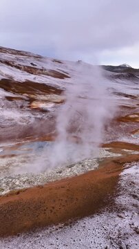 Vertical drone shot orbiting a powerful geothermal steam vent in Hverir Iceland