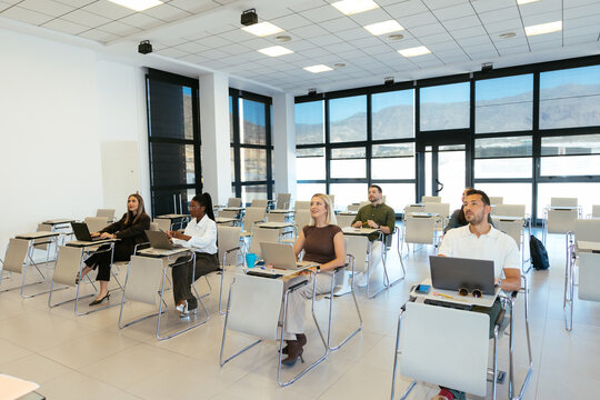 Diverse students learning in modern university classroom