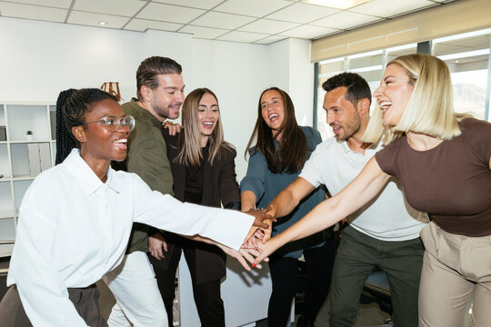Diverse business team stacking hands celebrating teamwork