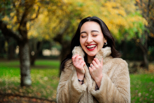 Joyful woman in warm coat with closed eyes 