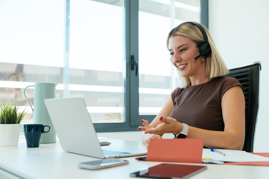 Smiling woman using headset for online video call