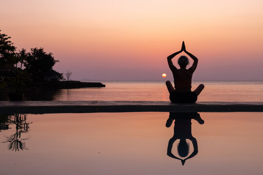 yoga and wellbeing background, woman silhouette at sunset