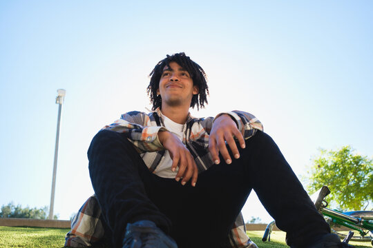 Young Man Relaxes Outdoors at Park on a Sunny Day. Copy space