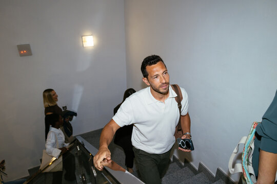 man walking up stairs in white polo shirt
