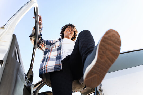Man Steps out of Vehicle on Clear Day in Outdoor Location. Copy space